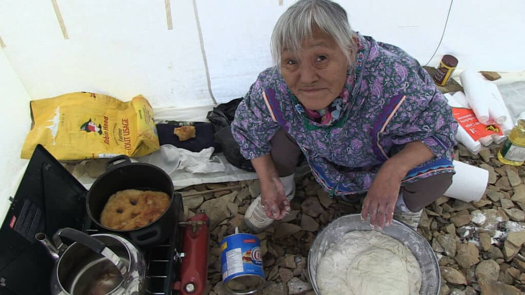 An Innuit woman prepares a meal along the Northwest Passage